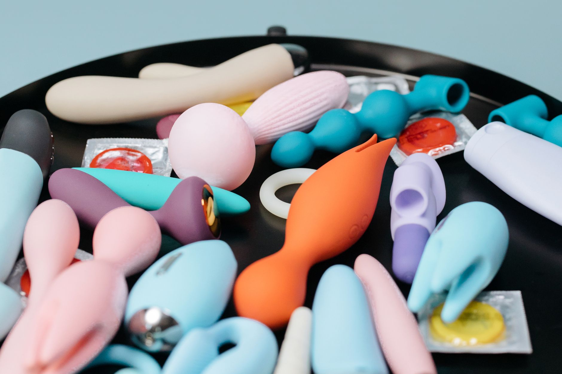 Three colorful vibrators arranged on white fabric, highlighting their smooth texture.