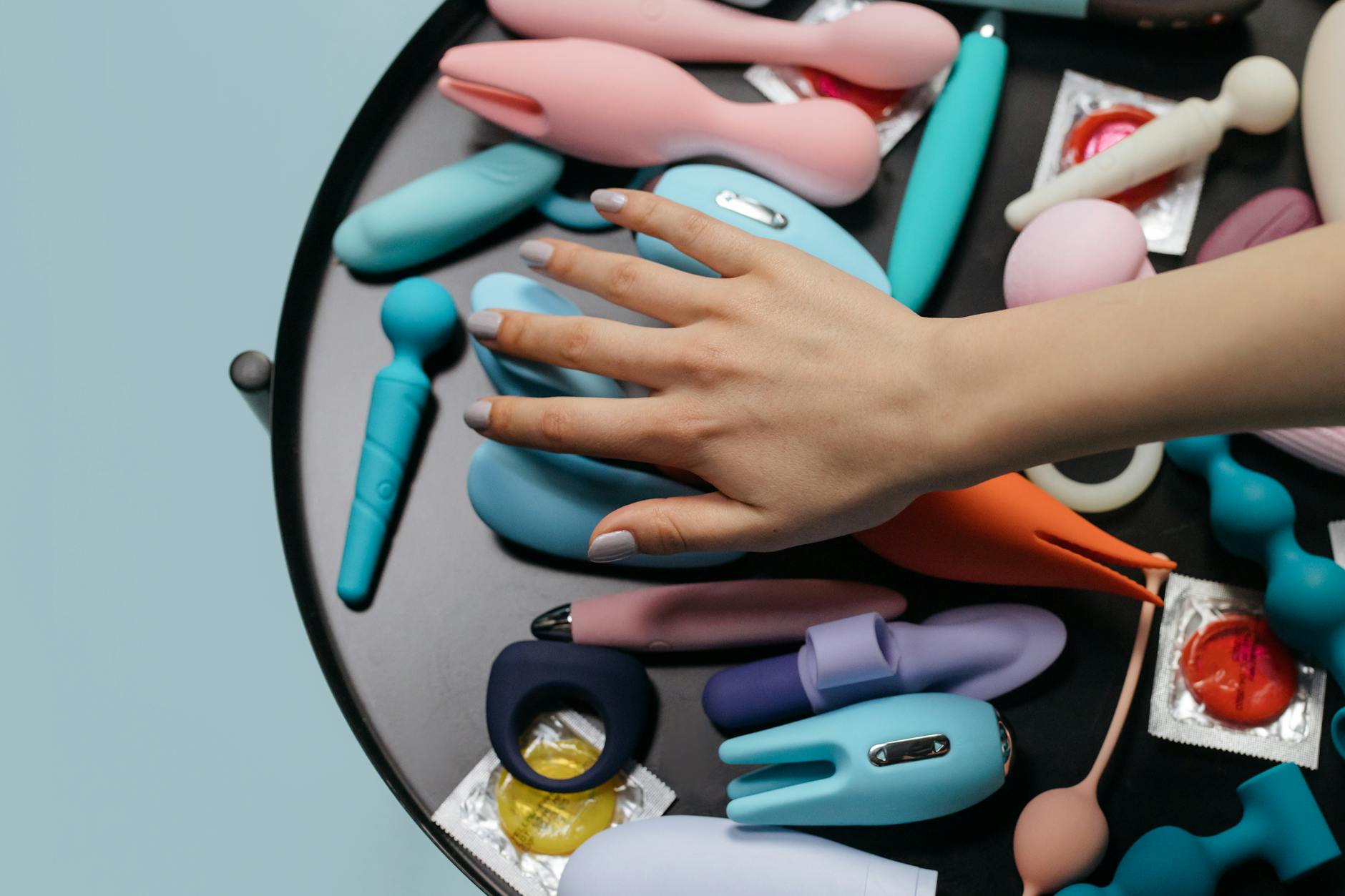Close-up of hands holding a vibrator against a knitted sweater