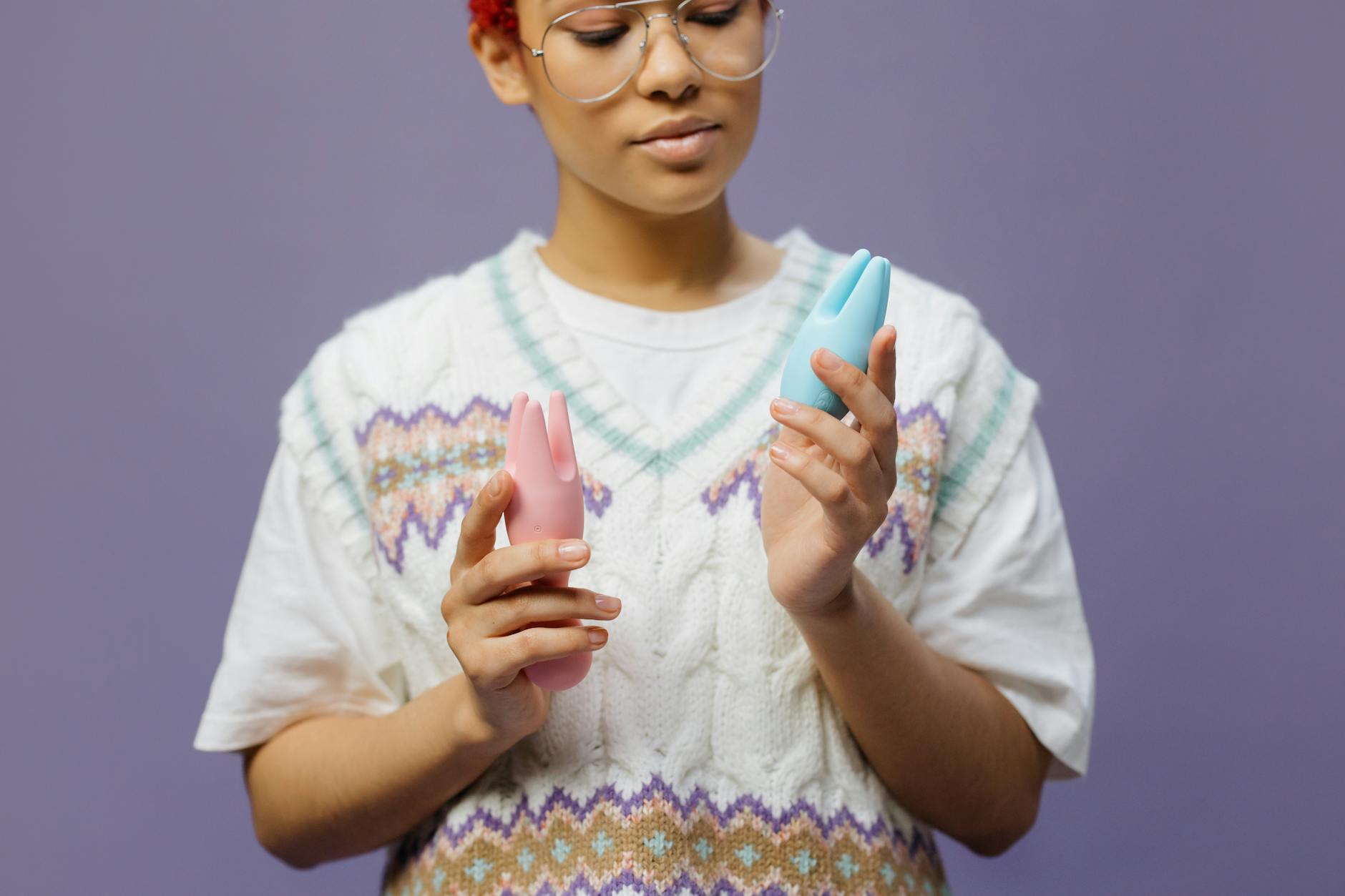 Woman holding colorful vibrators in a thoughtful, empowered moment