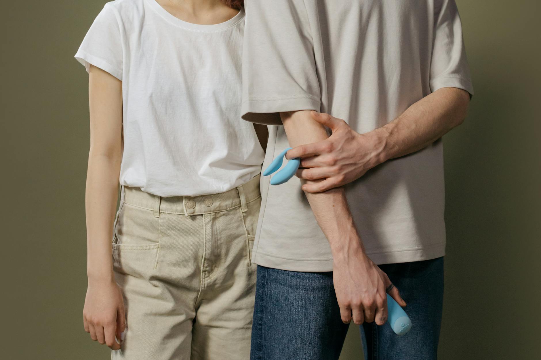 A couple standing together indoors, exploring intimacy with clitoral vibration devices