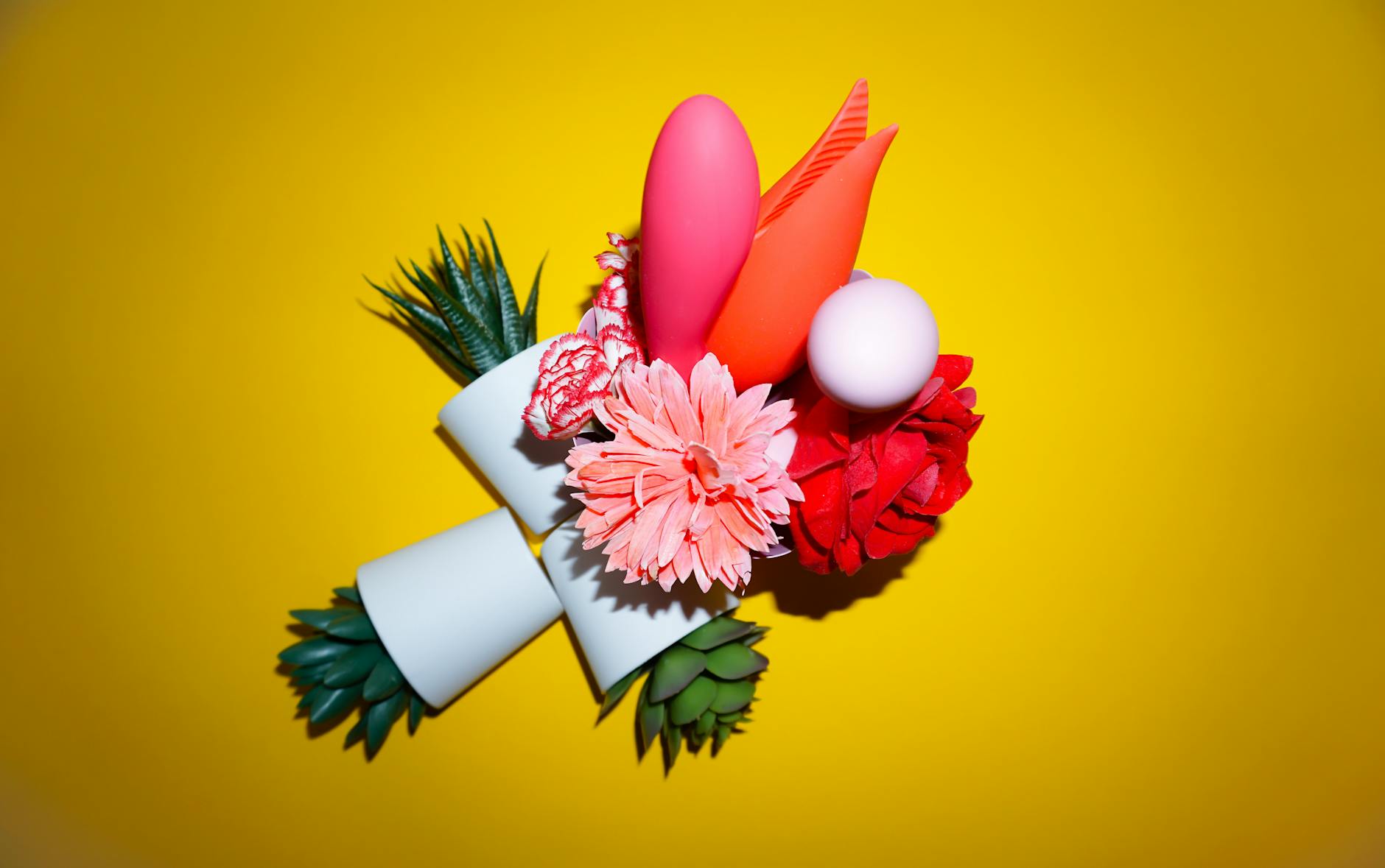 Yellow silicone vibrator surrounded by fresh fruit on bright background