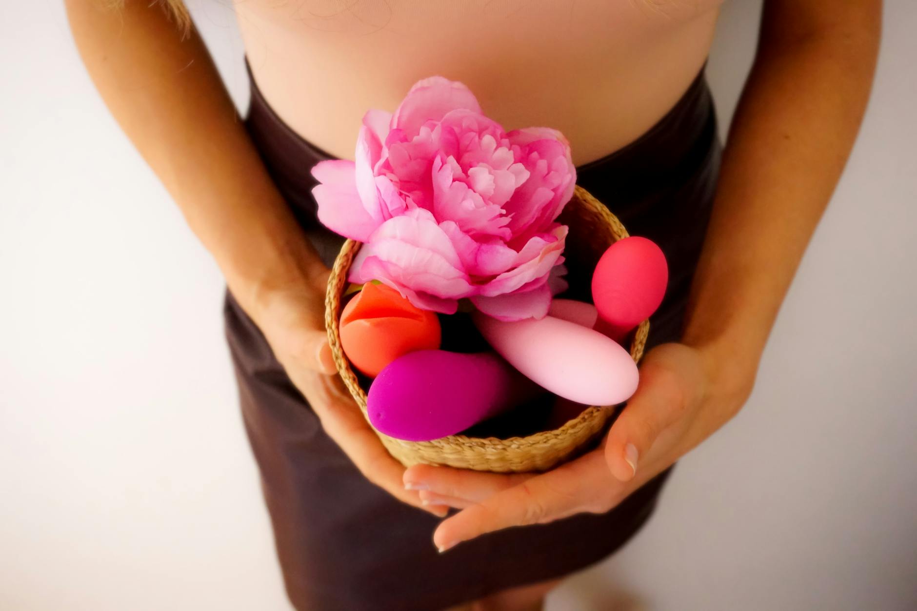 Hand selecting from a diverse array of colorful clitoral vibrators on a table